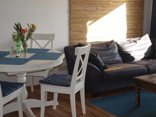 een woonkamer met een tafel en een bank bij Kajüthus Apartment 3 in Fehmarn