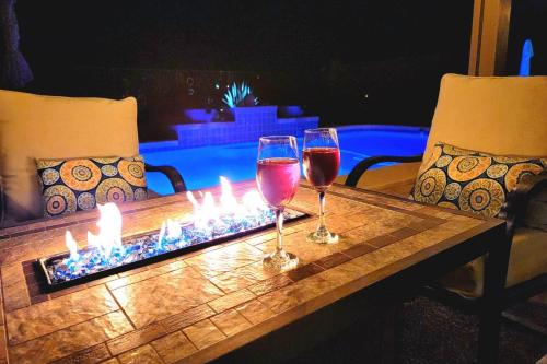 two glasses of wine on a table with a fire place at Honeysuckle Oasis in Gold Canyon