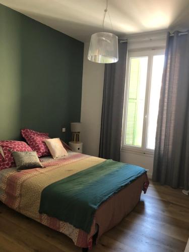 a bedroom with a large bed with a window at Très bel appart meublé classé 3 étoiles entièrement rénové et climatisé 50 m centre et 150 m plage in LʼÎle-Rousse