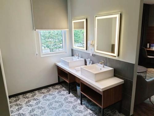 a bathroom with two sinks and two mirrors at NB HOTEL in Johor Bahru