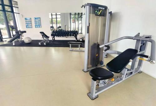 a gym with a treadmill and a chair in a room at Almas Suite Seaview & Netflix By STAY in Nusajaya