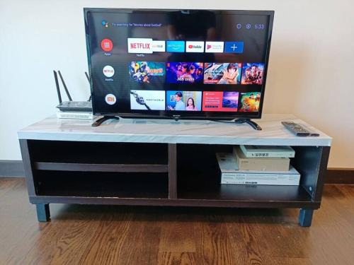 a tv sitting on top of a entertainment center at Almas Suite Seaview & Netflix By STAY in Nusajaya