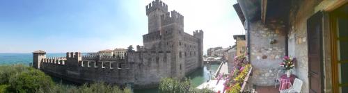 an old castle sitting on the water next to a building at Hotel Grifone in Sirmione