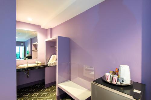 Baño púrpura con lavabo y espejo en Lilac Relax-Residence en Lat Krabang