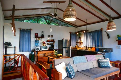 a living room with a couch and a kitchen at Alma Del Rio Eco-Comfort on the water in San Ignacio