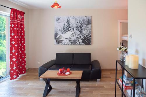 a living room with a couch and a table at Chalet Alte Post in Schwarzsee