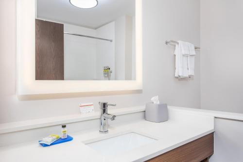 La salle de bains est pourvue d'un lavabo et d'un miroir. dans l'établissement Holiday Inn Express Williamsburg, an IHG Hotel, à Williamsburg