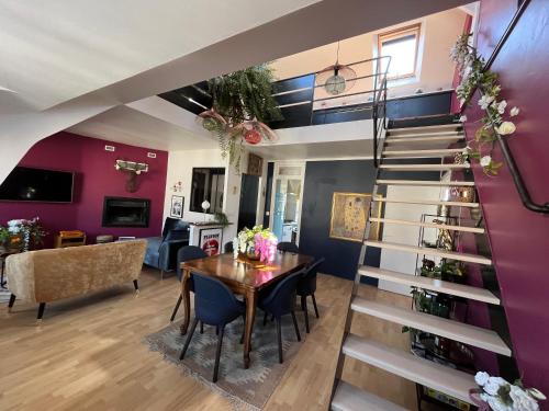 - un salon avec un escalier en colimaçon, une table et des chaises dans l'établissement Gallina, Duplex en centre ville sur le port de Caen, à Caen