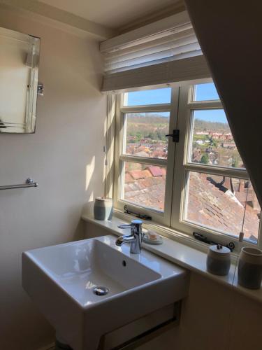 a bathroom with a sink and two windows at Little Gem on Bridgnorth's Cartway. River Views in Bridgnorth