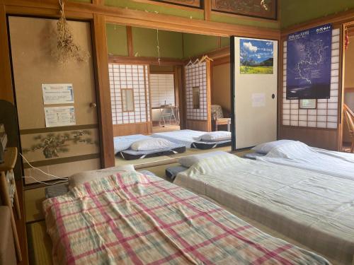 a room with three beds in a room at 古民家ゲストハウス大ちゃん家 in Shimanto