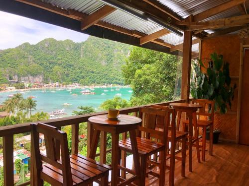 a balcony with chairs and a table and a view of the water at BaleCabugaoCottagesRental in El Nido