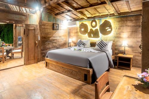 a bedroom with a bed in a room with wooden walls at PNB Bali Villas in Canggu