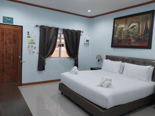 a bedroom with a bed with two teddy bears on it at Tong Chang Resort in Chumphon