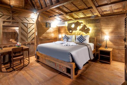 a bedroom with a bed in a room with wooden walls at PNB Bali Villas in Canggu