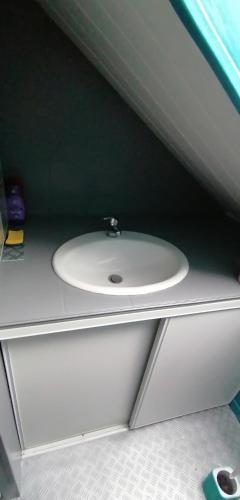 een badkamer met een witte wastafel op een aanrecht bij chambre à 800 mètres du mythique virage de Mulsanne in Mulsanne