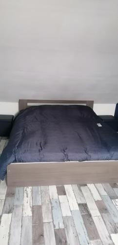 ein Bett mit blauer Decke in einem Schlafzimmer in der Unterkunft chambre à 800 mètres du mythique virage de Mulsanne in Mulsanne