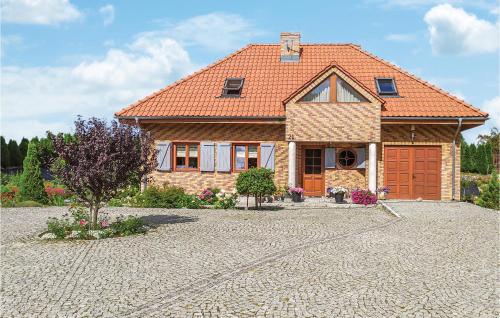 a brick house with an orange roof and a driveway at 3 Bedroom Awesome Home In Gardna Wielka in Gardna Wielka