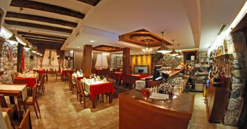 a restaurant with tables and chairs and a bar at Hotel - Kulla e Zenel Beut in Peje