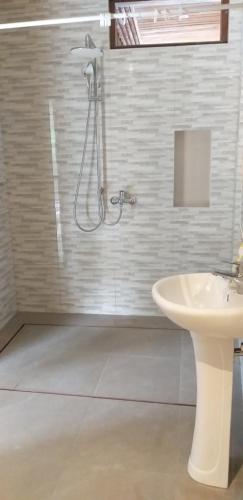 La salle de bains est pourvue d'une douche et d'un lavabo. dans l'établissement Maru fortuna Villa, à Tegalalang