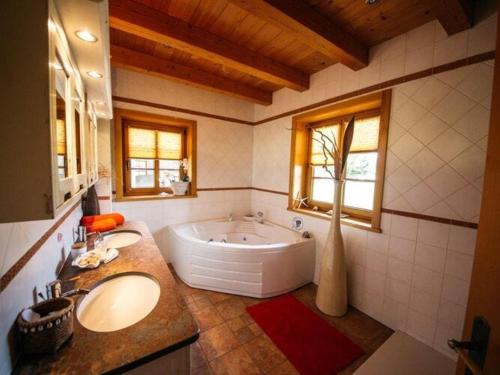 een badkamer met 2 wastafels en een groot bad bij Holiday Home amid the walking and cycling area of Petzenland in Unterlibitsch