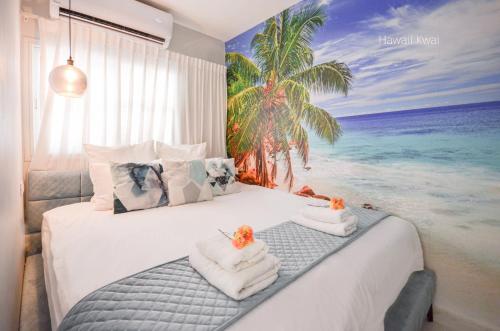 a bedroom with a bed with a painting of the beach at Yalarent Hawaii Complex Boutique & Garden Hotel Apartments Eilat in Eilat