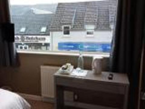 a room with a bed and a table with a window at The Skye Bridge Hotel in Kyle of Lochalsh