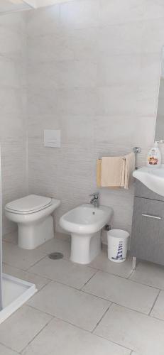 bagno bianco con servizi igienici e lavandino di Casa matilde a Roccaforzata