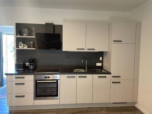 a kitchen with white cabinets and a sink at Sorinas Home WB16 Top 13 in Wagersbach