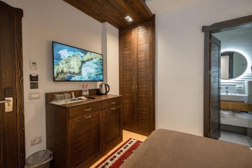 1 dormitorio con 1 cama y TV en la pared en Hotel - Kulla e Zenel Beut en Peje