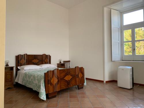 a bedroom with a wooden bed and a window at Guest house Il Palazzo Marchesale in Carife