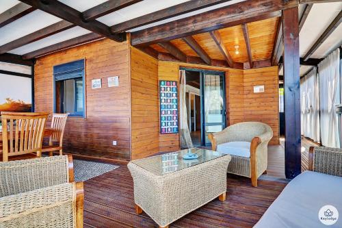 a porch with wicker chairs and a table at Kaz Bois Blanc, classée 3 étoiles - Vue mer - Les Avirons in Les Avirons