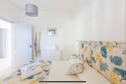 una camera bianca con un letto e asciugamani di Stella Marina - Porto Pirrone Paradise Beach a Leporano