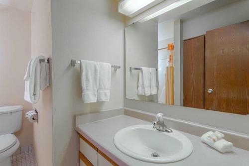 a bathroom with a sink and a toilet and a mirror at Norwood Inn & Suites Indianapolis East Post Drive in Indianapolis