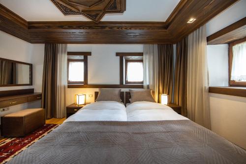 a bedroom with two beds and two windows at Hotel - Kulla e Zenel Beut in Peje