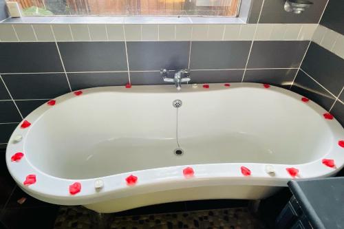 a bath tub with red flowers on it in a bathroom at The Bliss Boutique in Louis Trichardt