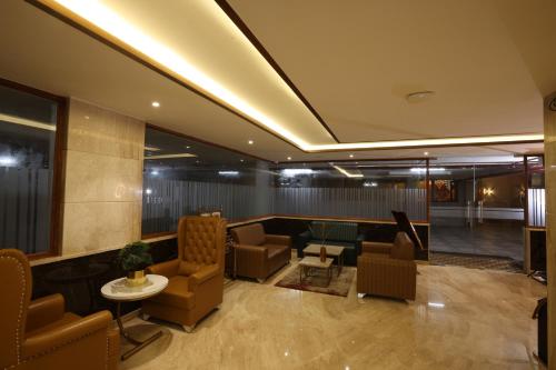 a lobby with chairs and a couch and a table at Royal Plaza Suites by RAK Rooms, Mangaluru in Mangalore