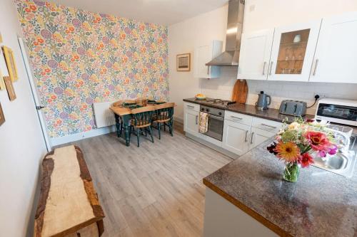 a kitchen with a vase of flowers on a counter at Daffodil House in Cockermouth