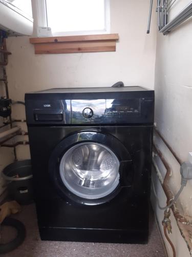 uma máquina de lavar e secar roupa num pequeno quarto em Carvetii - Laurel House - 2 bed House sleeps up to 8 