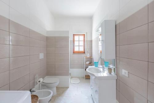 La salle de bains blanche est pourvue de toilettes et d'un lavabo. dans l'établissement Stella Marina - Porto Pirrone Paradise Beach, à Leporano