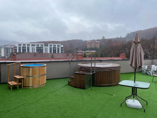 an outdoor patio with two hot tubs and an umbrella at Sunrise Aparts in Polyana