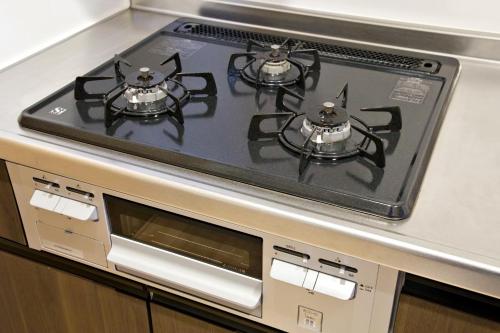a stove top oven with two burners on it at メイスン倶楽部 安里 4F in Naha