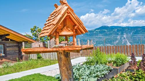 a bird house on a wooden pole in a garden at Residence Ferienwohnungen Sonnegg in Vollan