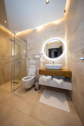 a bathroom with a sink and a toilet and a mirror at Hotel - Kulla e Zenel Beut in Peje