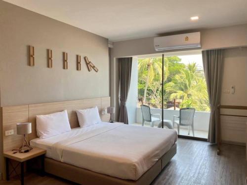 a hotel room with a bed and a balcony at Rayong Chalet Hotel And Resort in Klaeng