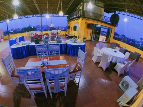 a restaurant with white tables and blue chairs at Anaya Hotel and Ballroom in Medan