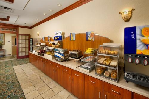 a fast food restaurant with a counter with pastries at Holiday Inn Express Hotel & Suites Lenoir City Knoxville Area by IHG in Lenoir City