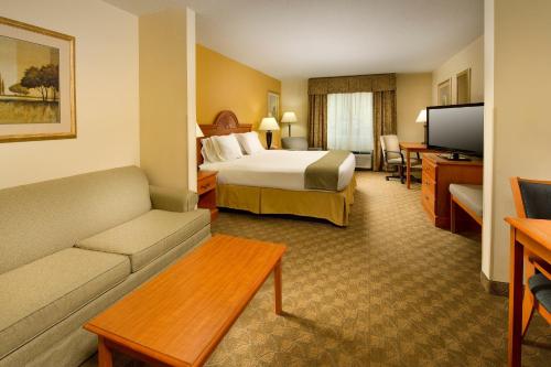a hotel room with a bed and a couch at Holiday Inn Express Hotel & Suites Lenoir City Knoxville Area by IHG in Lenoir City