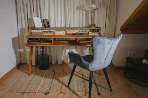 a desk with a chair and a desk with books at Conacul Sanct Gurgh in Cormaia