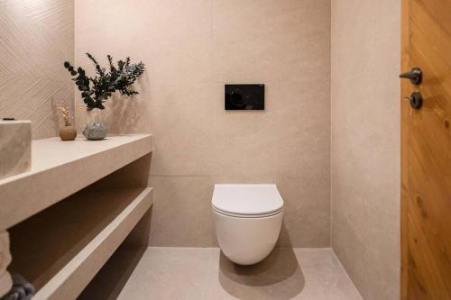 a bathroom with a white toilet and a sink at CasaCarma II, private pool, boho design, tradition in Lachania