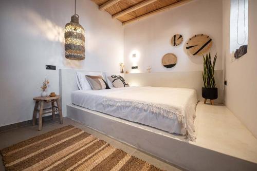 een slaapkamer met een bed in een witte kamer bij CasaCarma II, private pool, boho design, tradition in Lachaniá